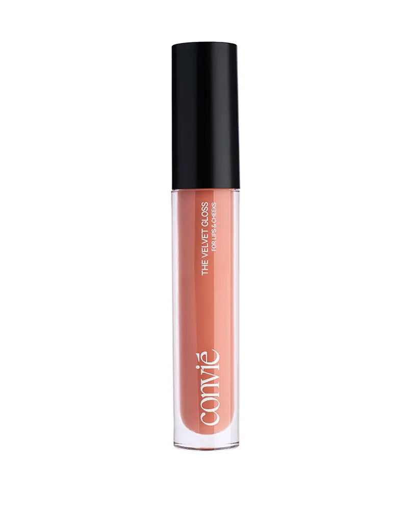 a nude lip gloss in a clear bottle with black cap standing upright