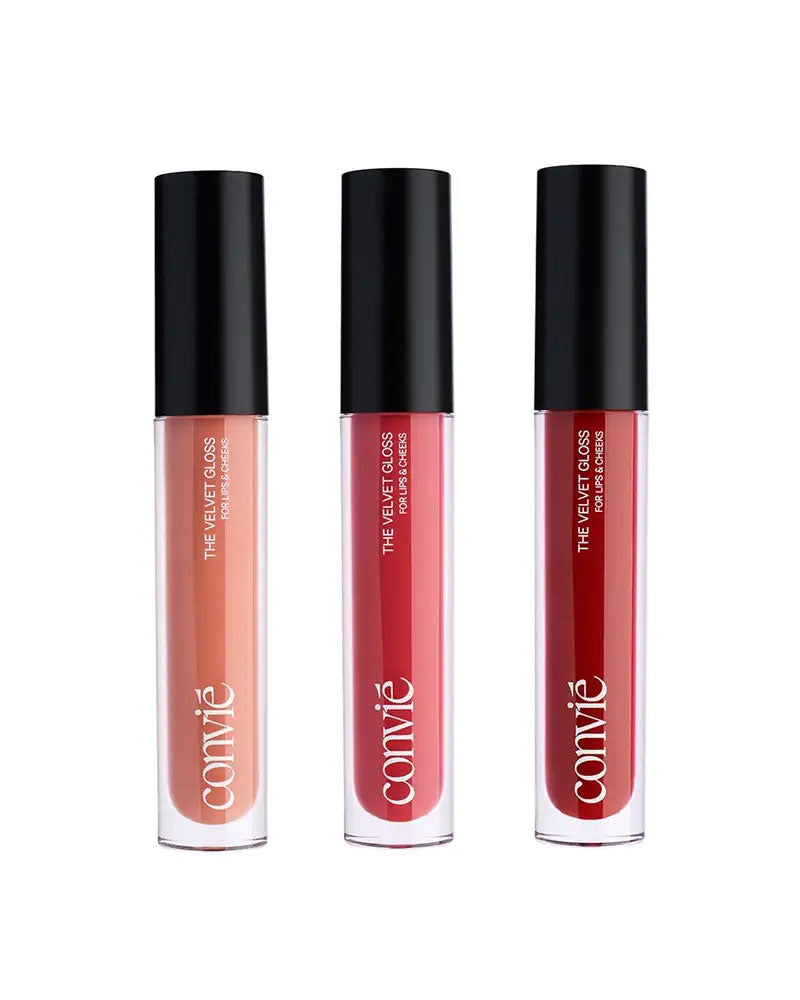 a beige, pink, and red lip gloss all standing in a row together