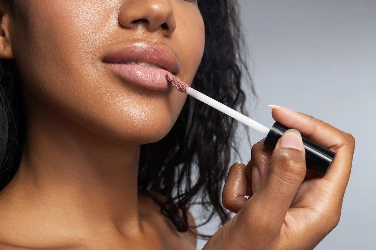 Woman putting on Lip Gloss