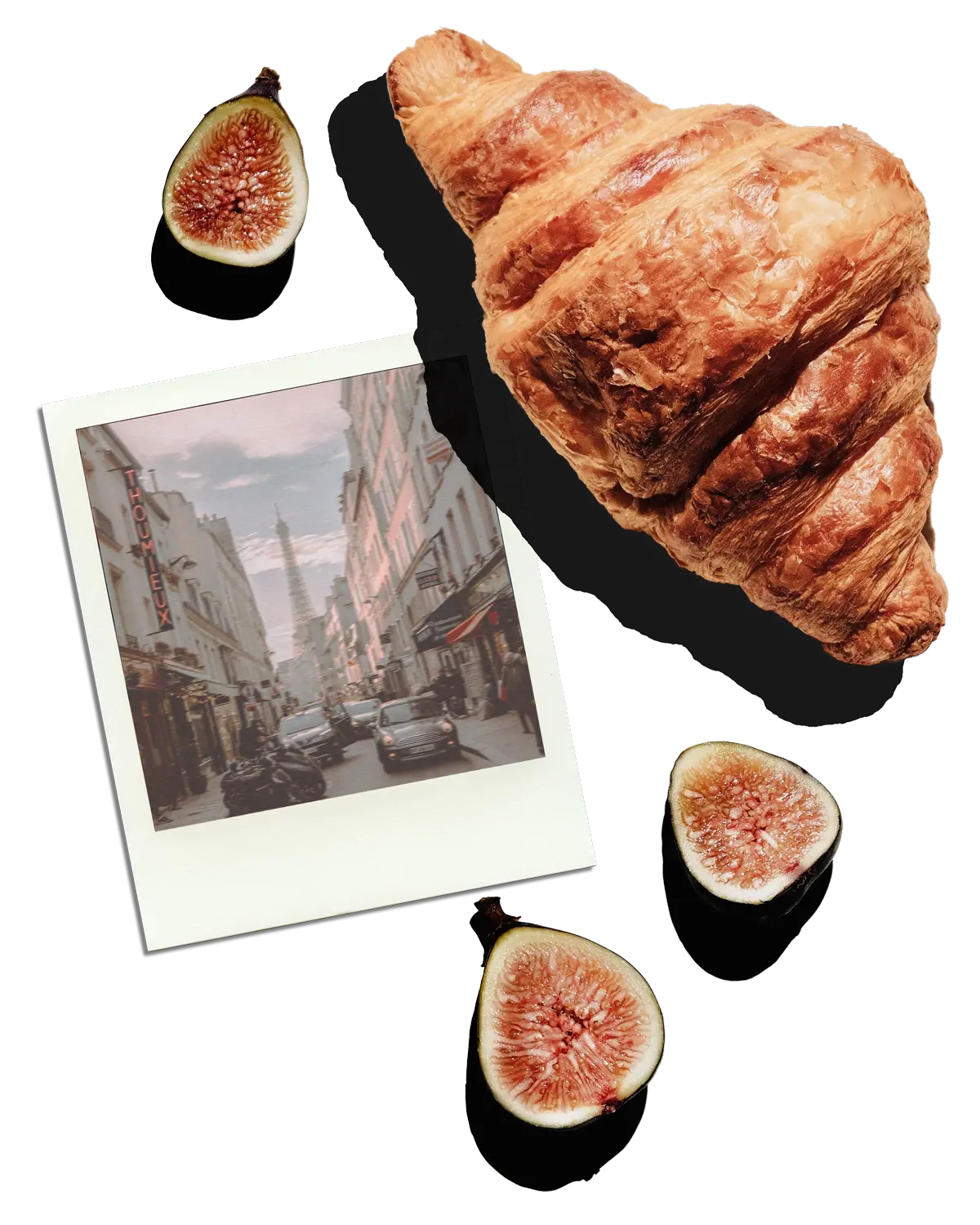 a croissant and figs scattered on a white background with a polaroid photograph of the Eiffel Tower