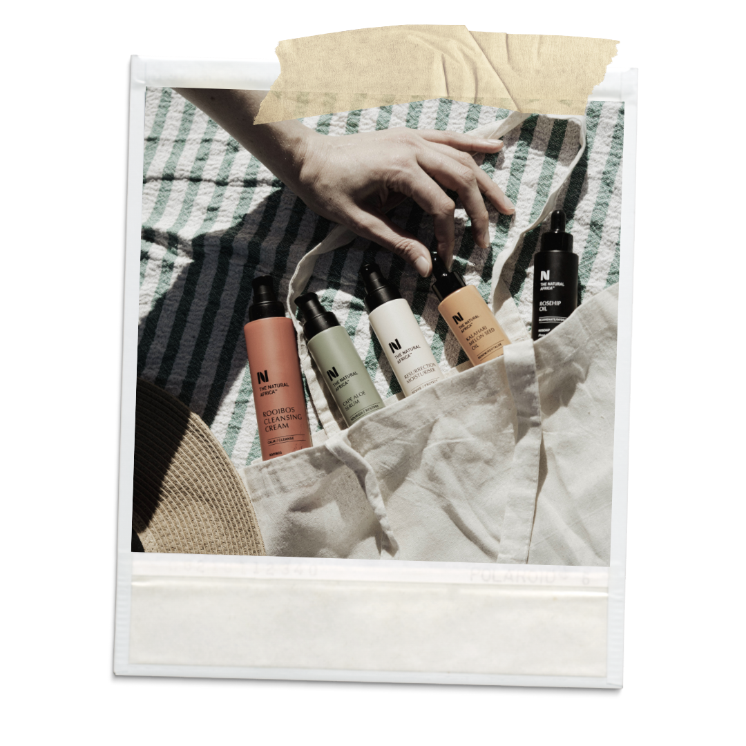 A polaroid picture of 5 skincare bottles laying on a beach blanket next to a canvas tote bag. 